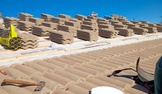 A closeup view of a Tucson roofing installation project, showing shingles being installed on the roof by professional roofers.